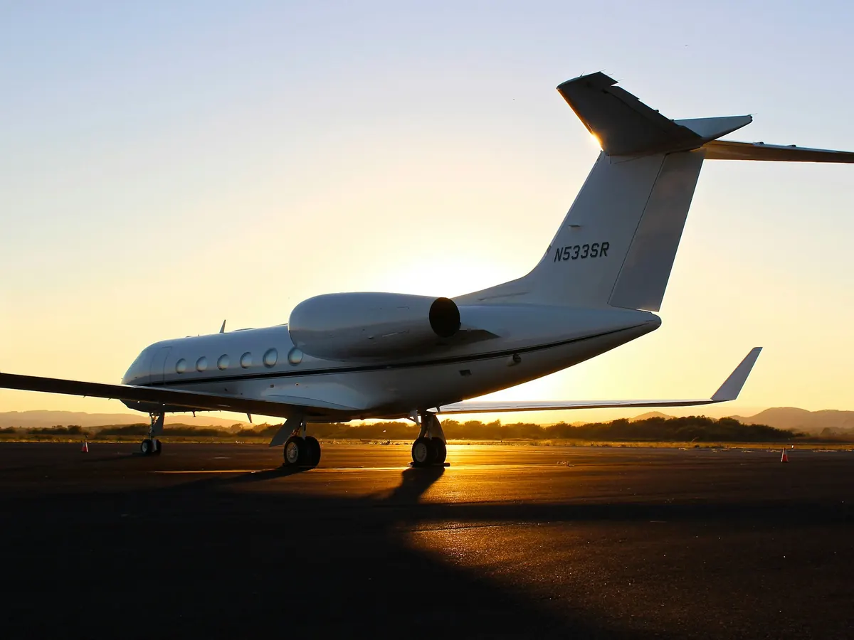 Large cabin jet silhouetted against a setting sun