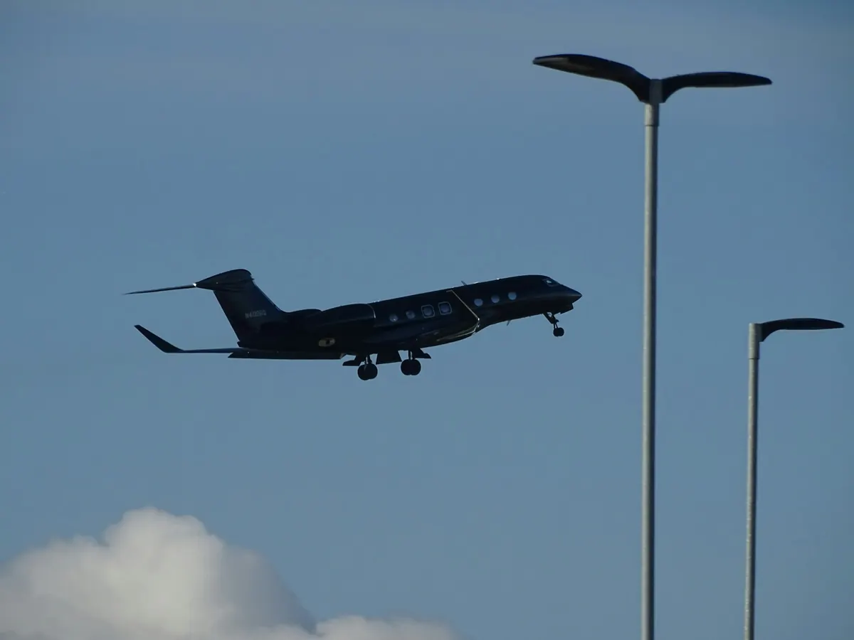 Business jet climbing away past street lights