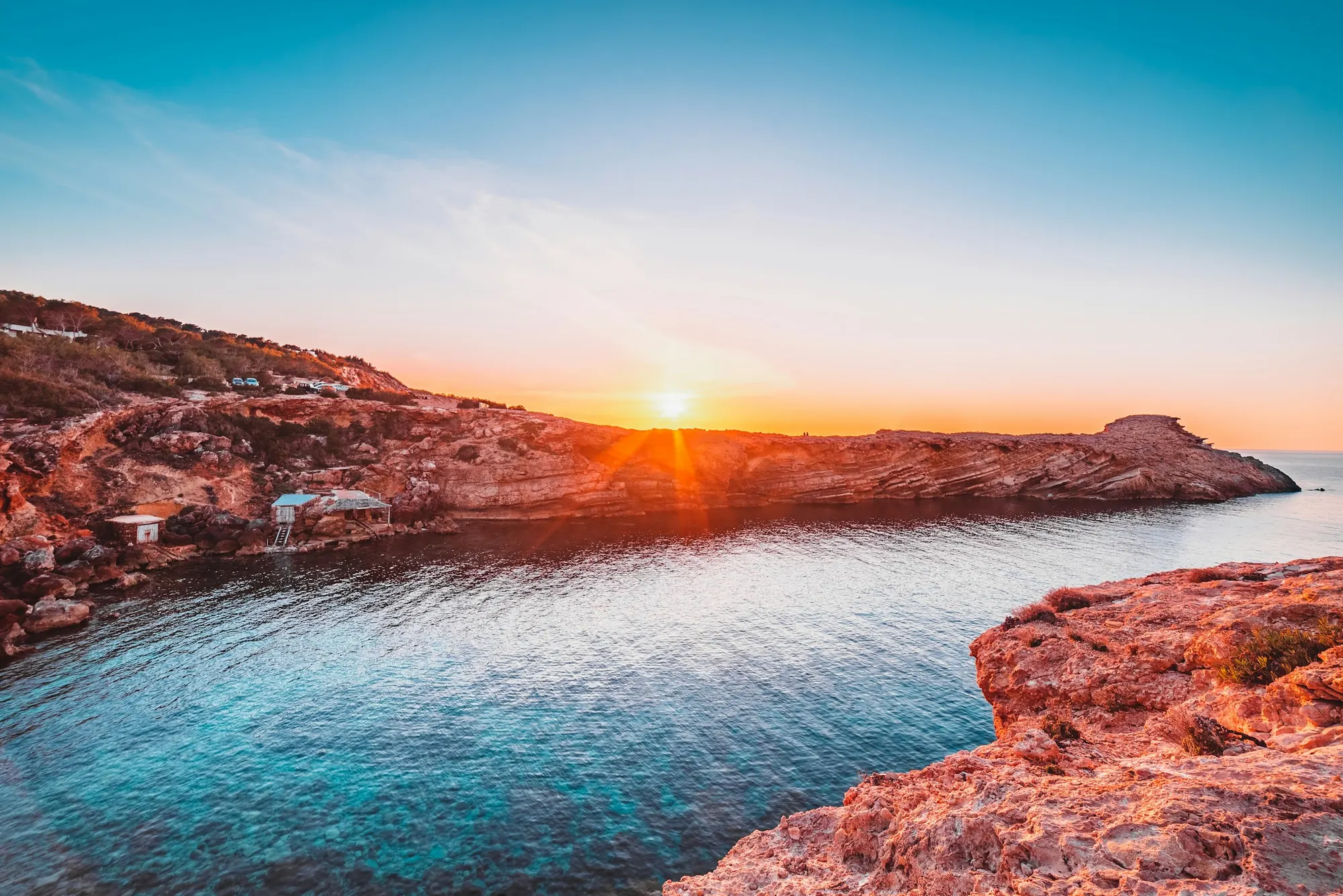 Red cliffs and the sea at sunset on Ibiza's coast