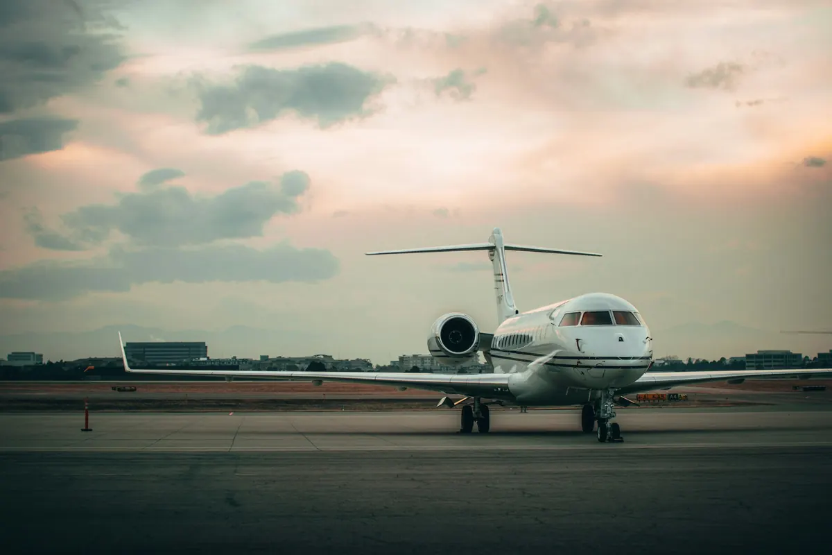 Business jet parked on an airport ramp as the sun goes down